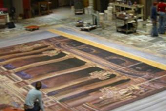 an overhead look at an artist kneeling beside a large painted backdrop