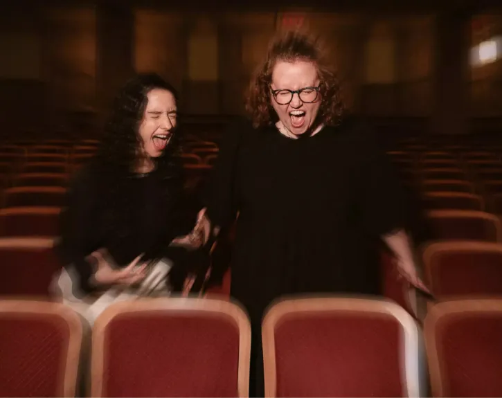 Photo of Kimberly Belflower and Danya Taymor screaming in theatre seats
