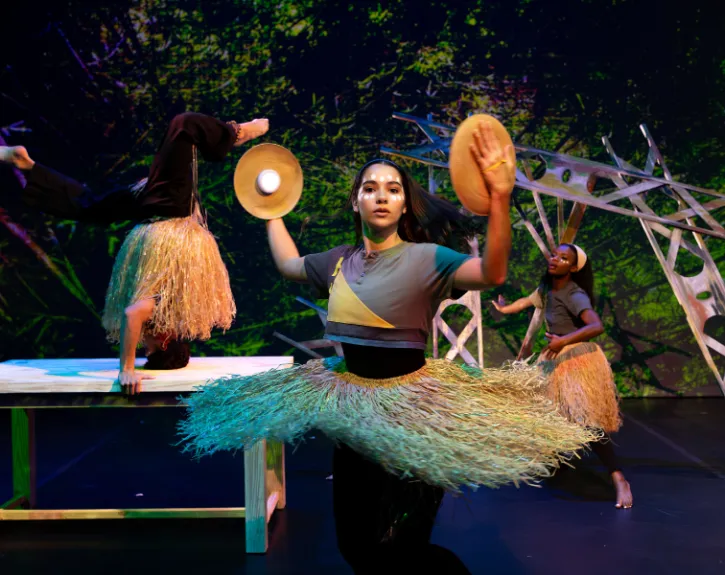 A woman in a grass skirt spinning