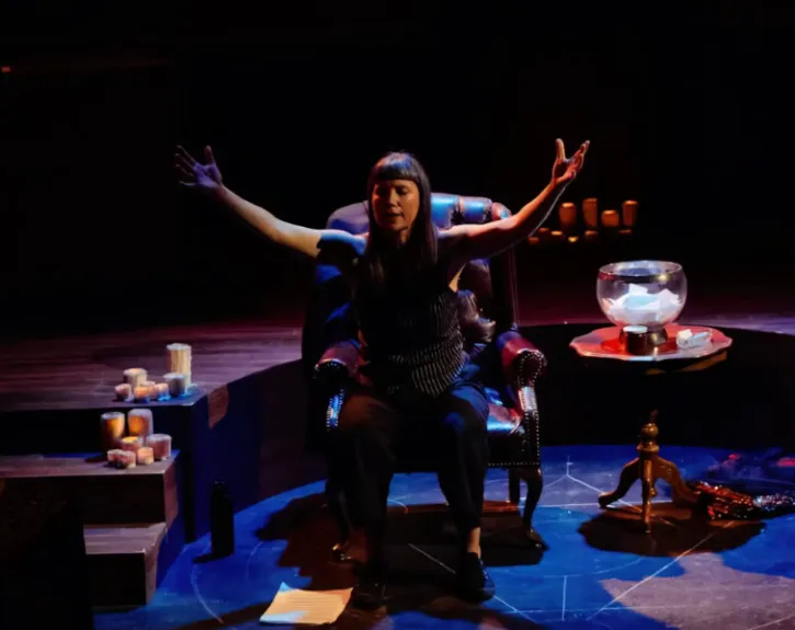 A woman closes her eyes and extends her arms into the air
