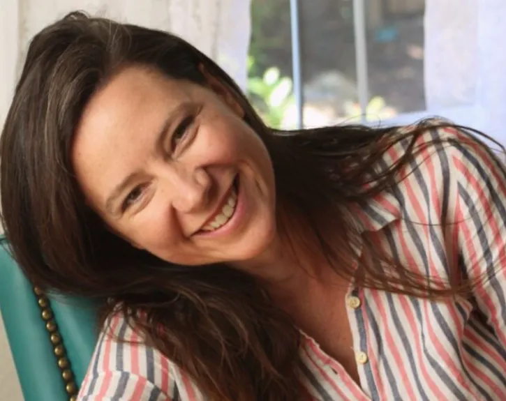 A woman with long brown hair smiles