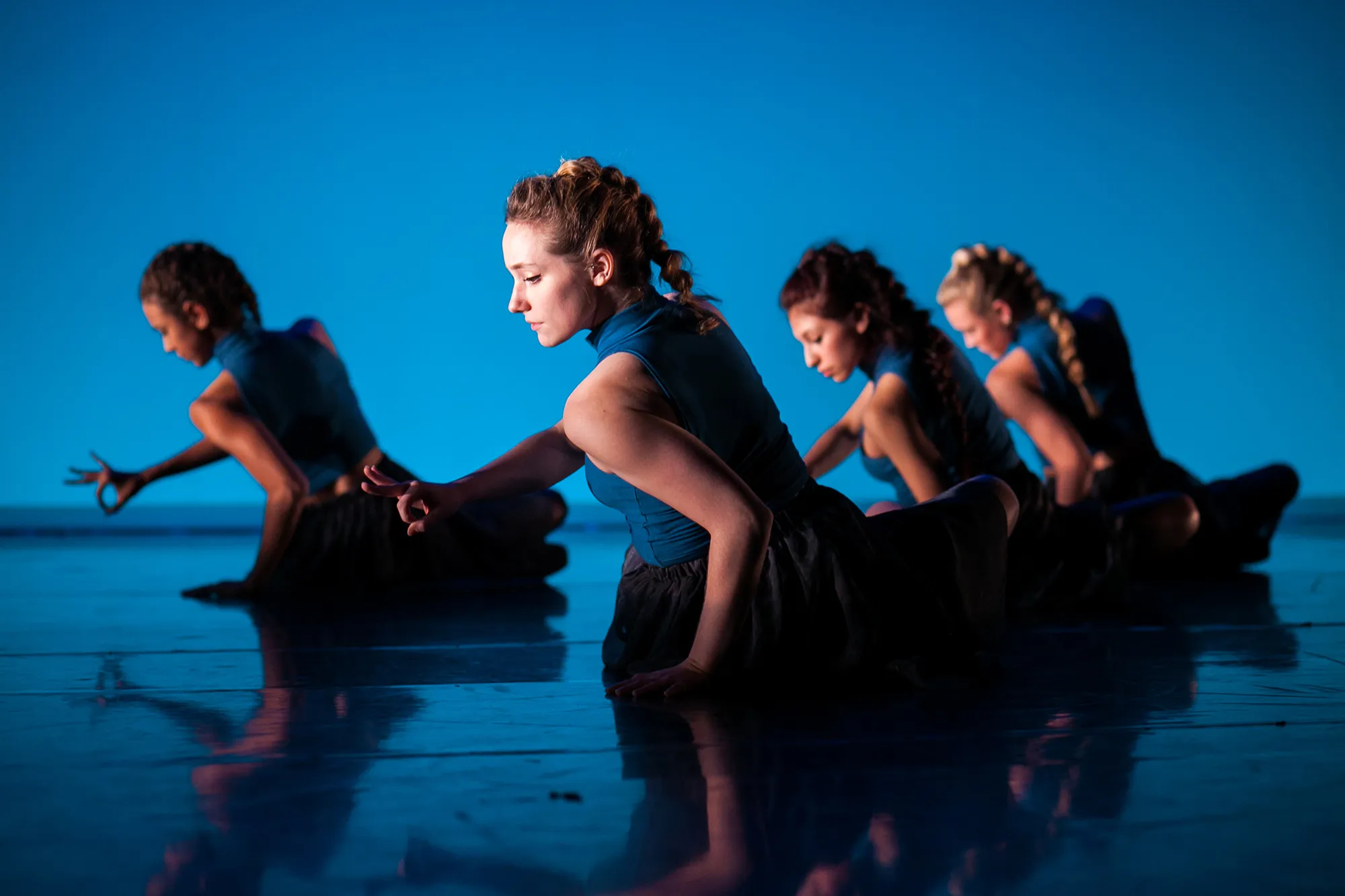 "Introspection" by Rachel Perry, performed in "Fall for Dance"; Photo: Lawrence Peart four dancers on the ground against a blue backdrop