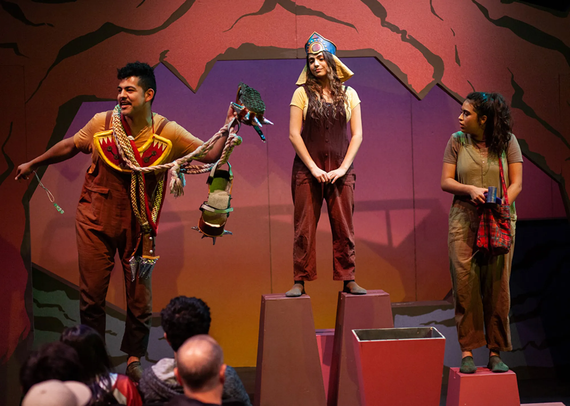 an actor and two actresses stand on platforms of different heights