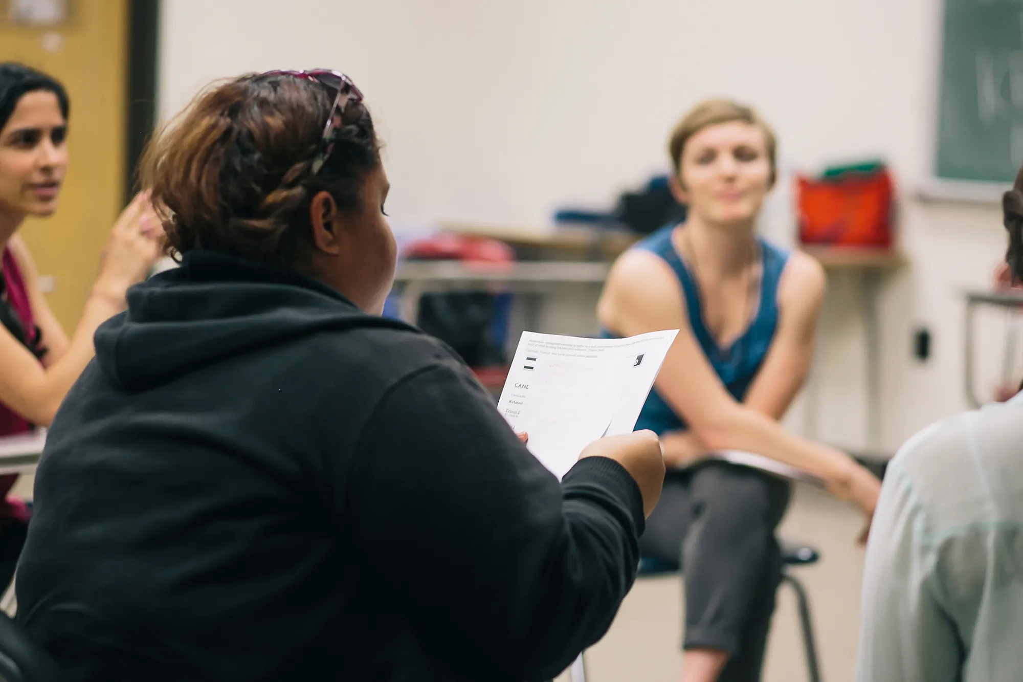 woman reading a document while others look on