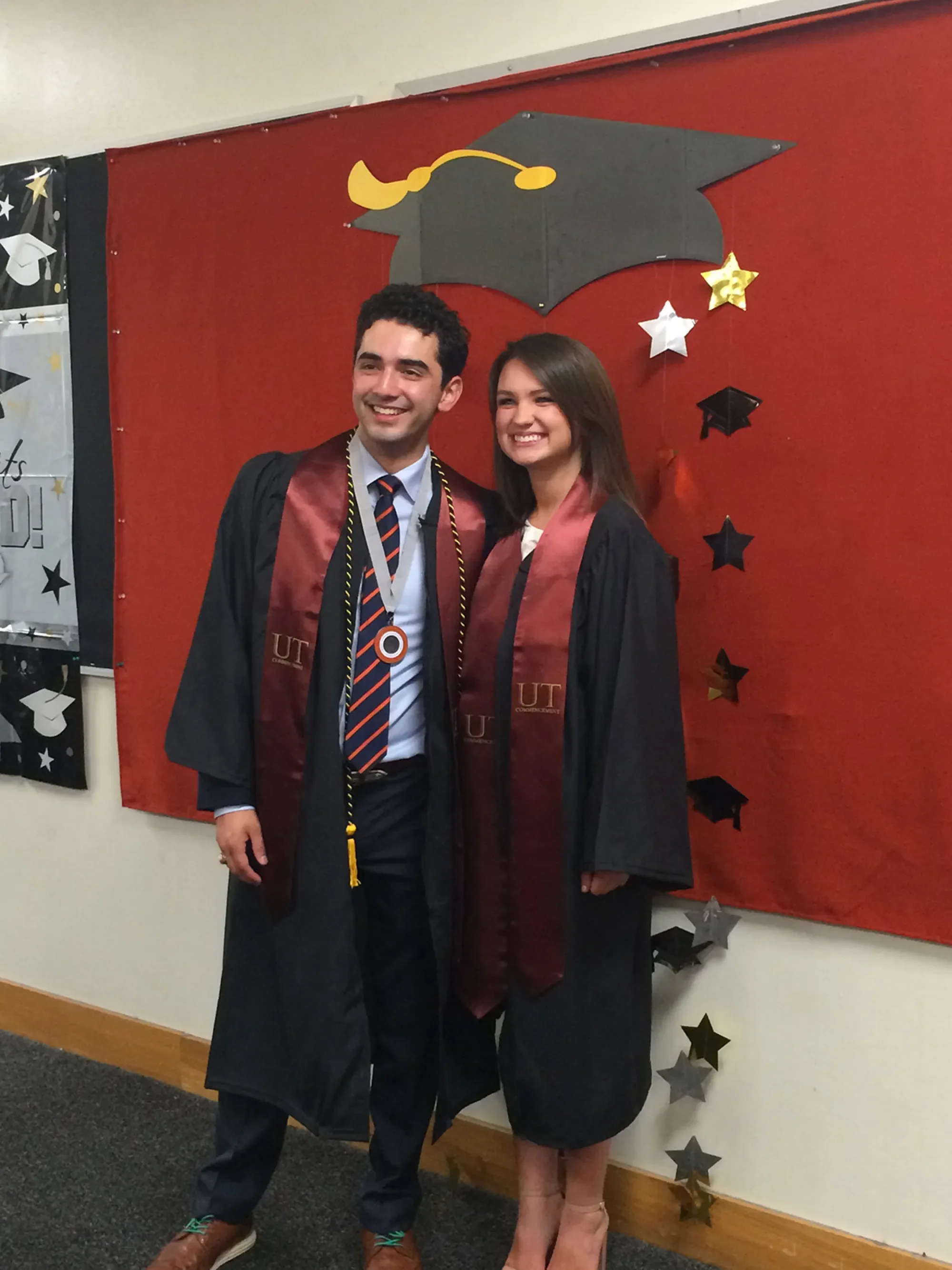 two graduates smiling