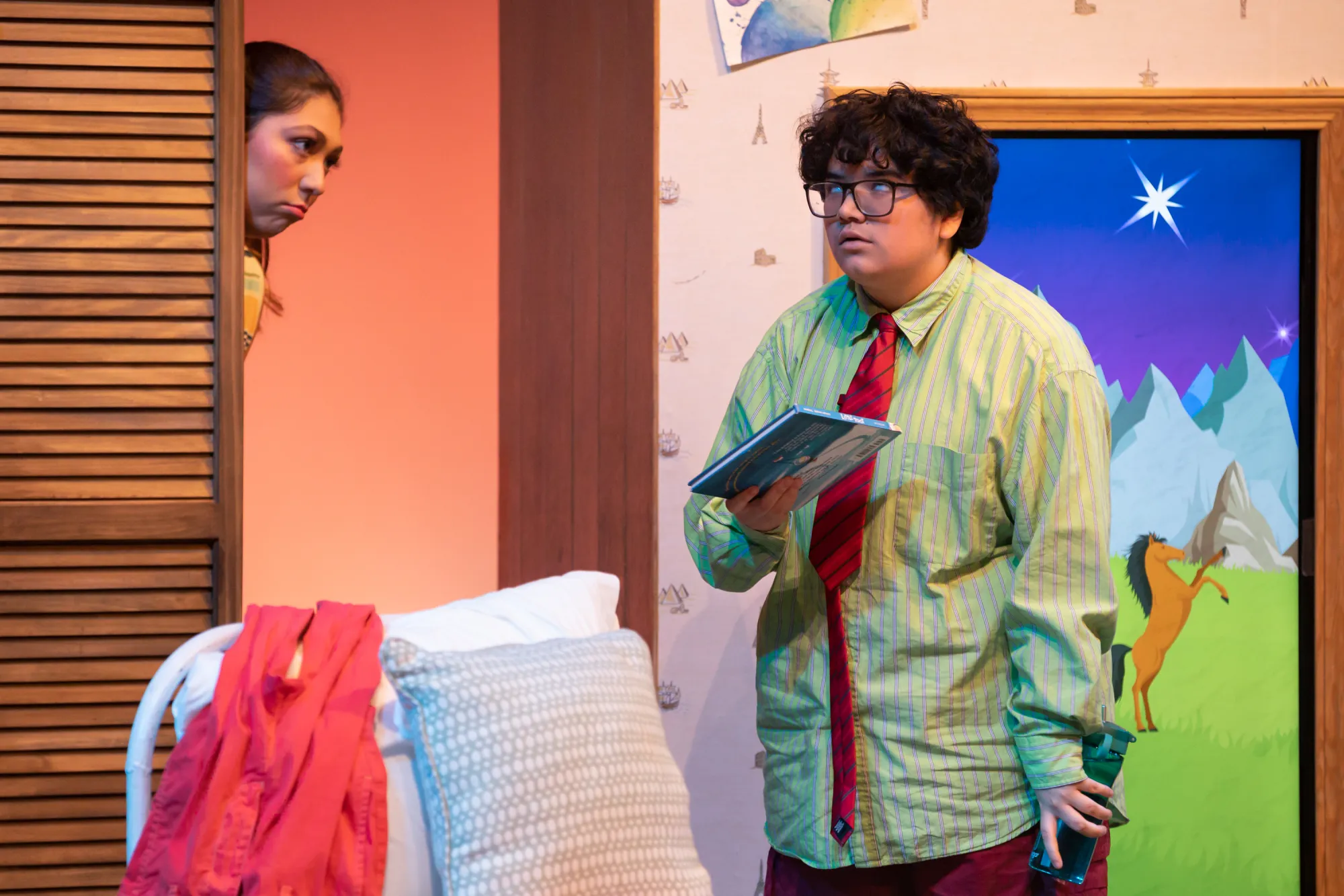 Older brother, Leo Martinez played by Gibby Reyes stands with their eyes rolled in annoyance in response to their younger sister, Lizzy Martinez's pestering. Lizzy is portrayed by Katya Lopez.