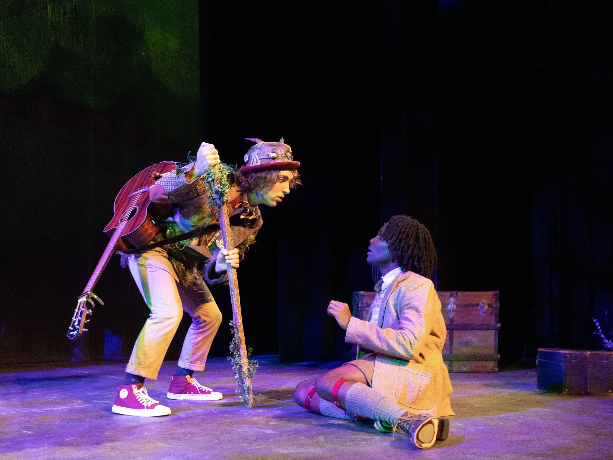 Old Magic Man, played by Oren Ederi, leans down to whisper whimsical words into the ears of James, played by Trevor Gatabaki