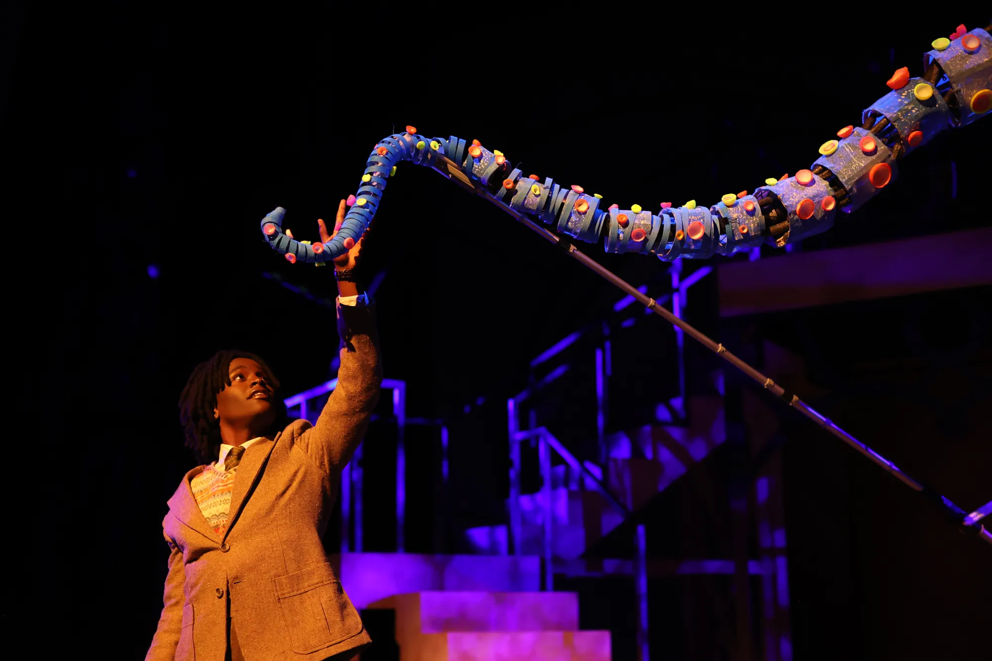 James, played by Trevor Gatabaki, reaches for a tentacle puppeted by the students