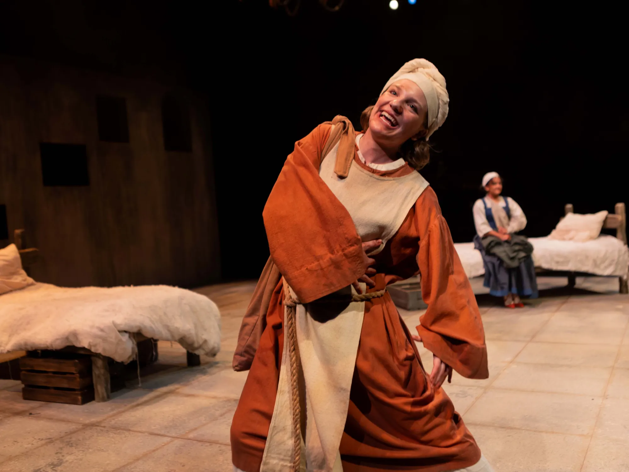 Whimsical Hunna, played by Ella Eavenson, welcomes new outcast Nicole, portrayed by Carlise Rosa, to the church.
