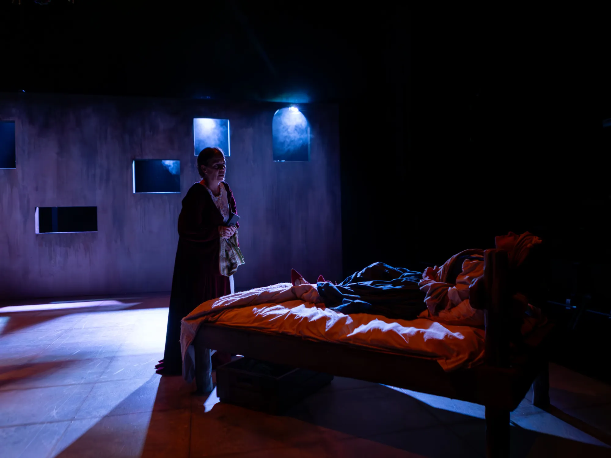Nicole played by Carlise Rosa suffers in bed. Lady Marguerite stands above her. Moonlight pours in from the windows.