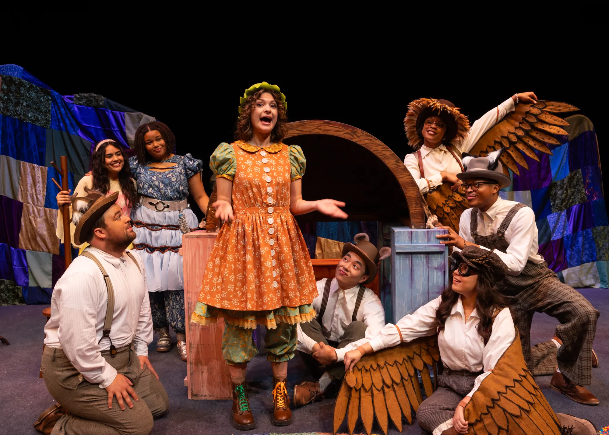 A girl is surrounded by a group of people wearing wings