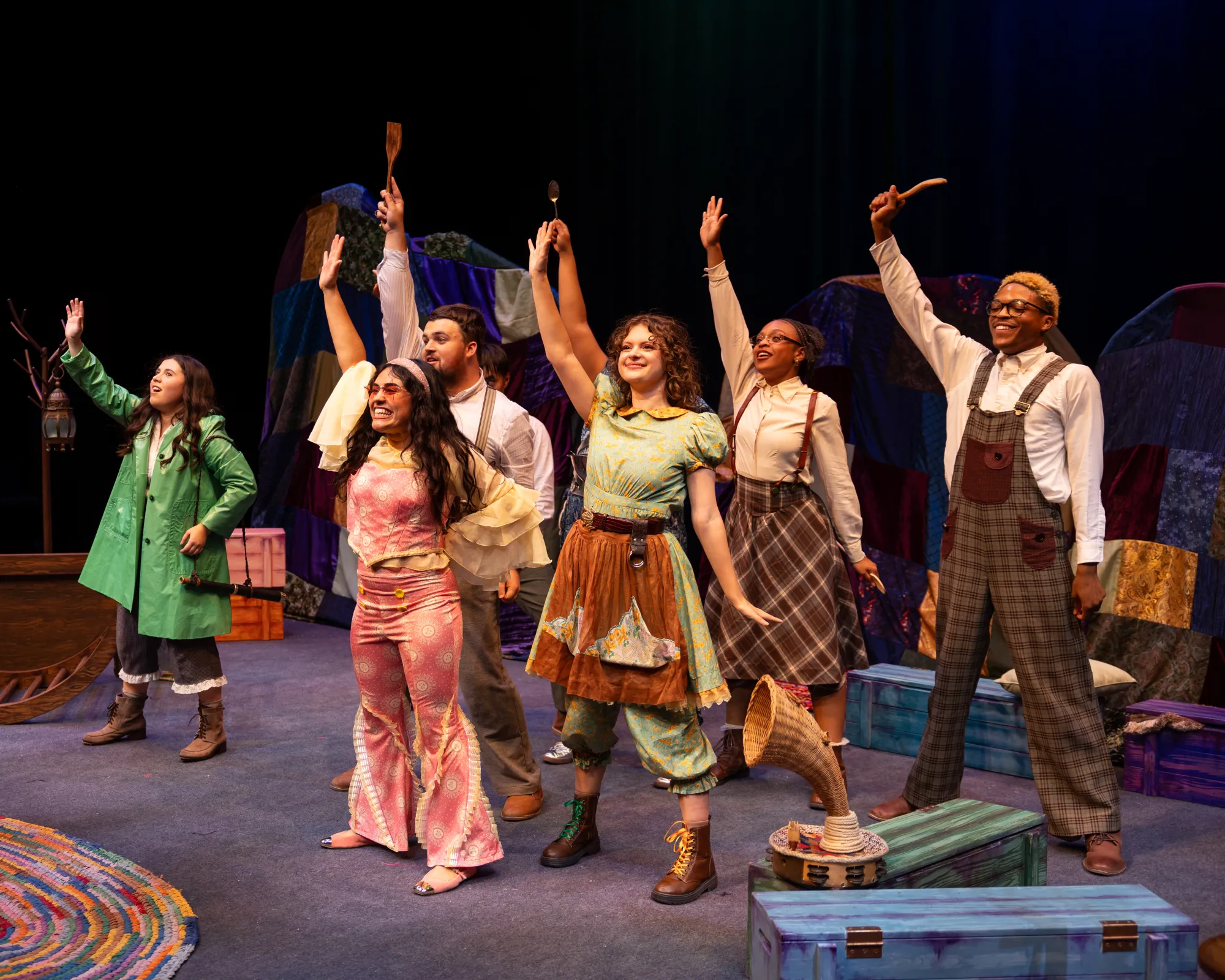 A crowd of people brandish cooking utensils