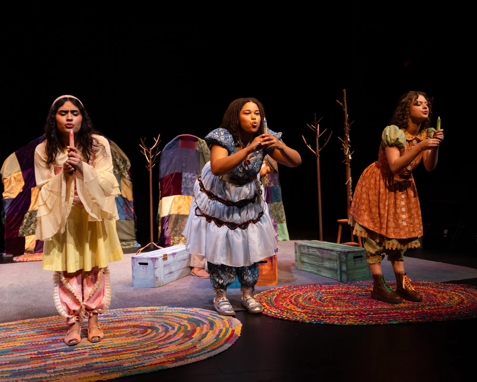 Three girls blowing out candles