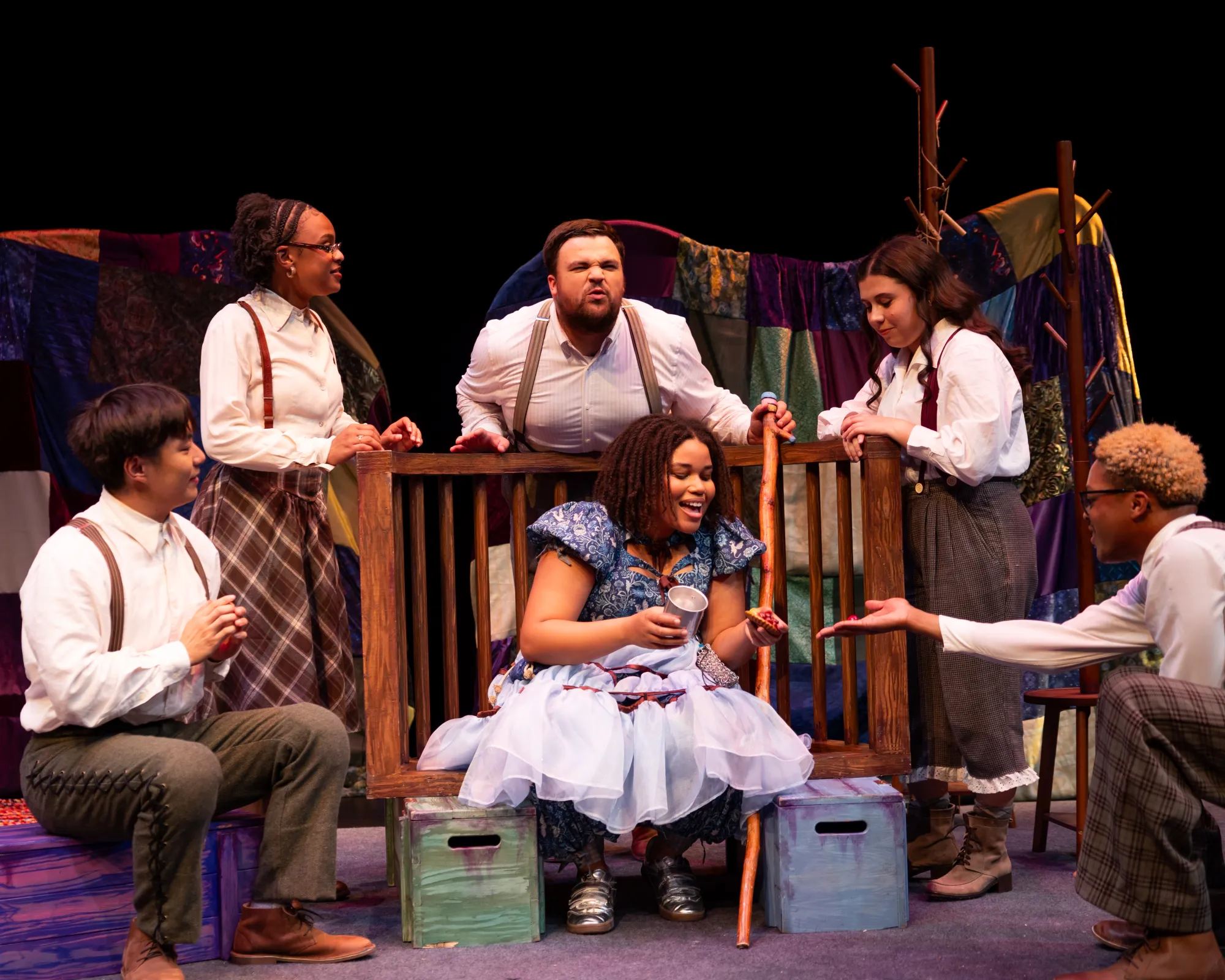 A crowd gathers around a girl holding a pie