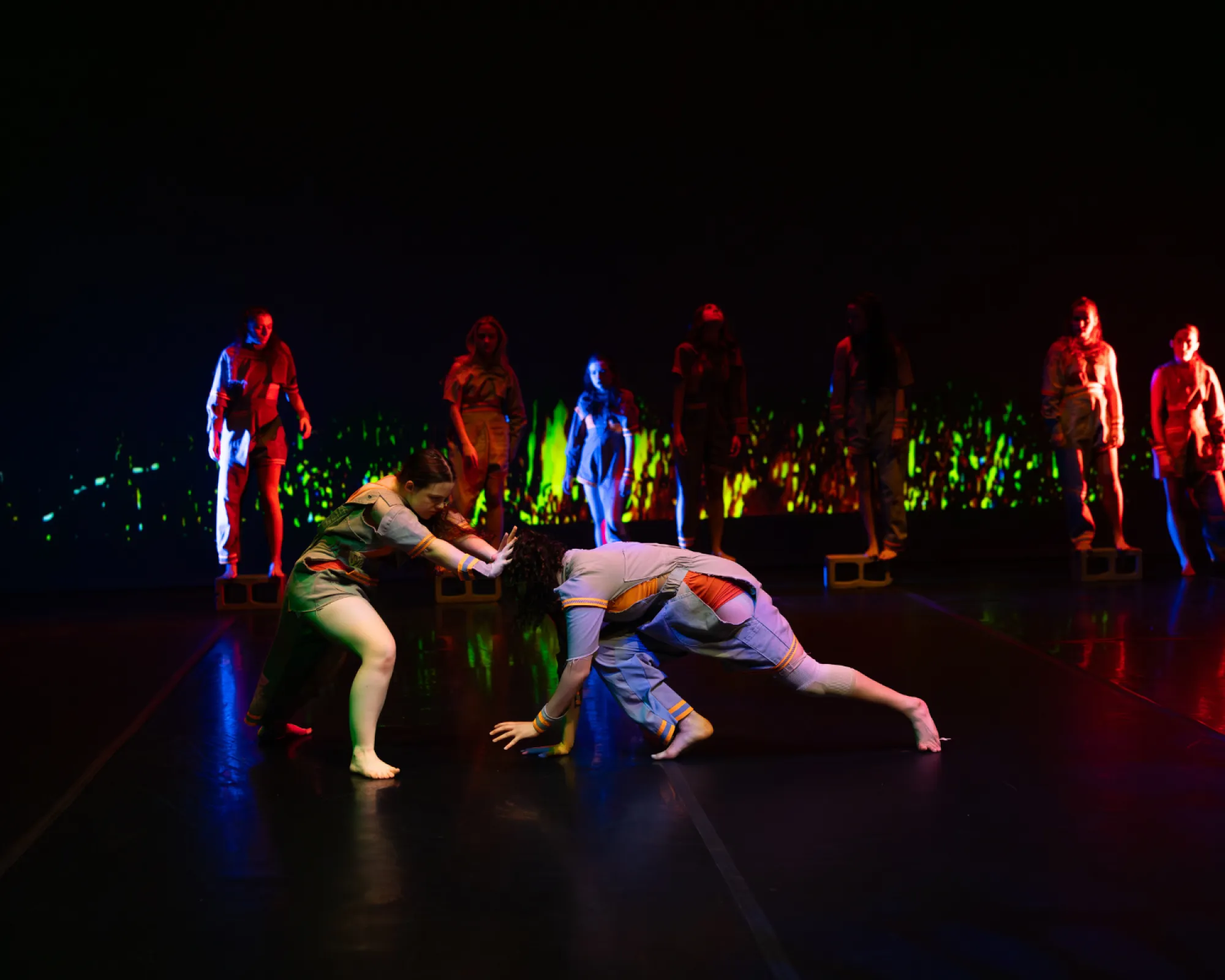 Two dancers push against each other