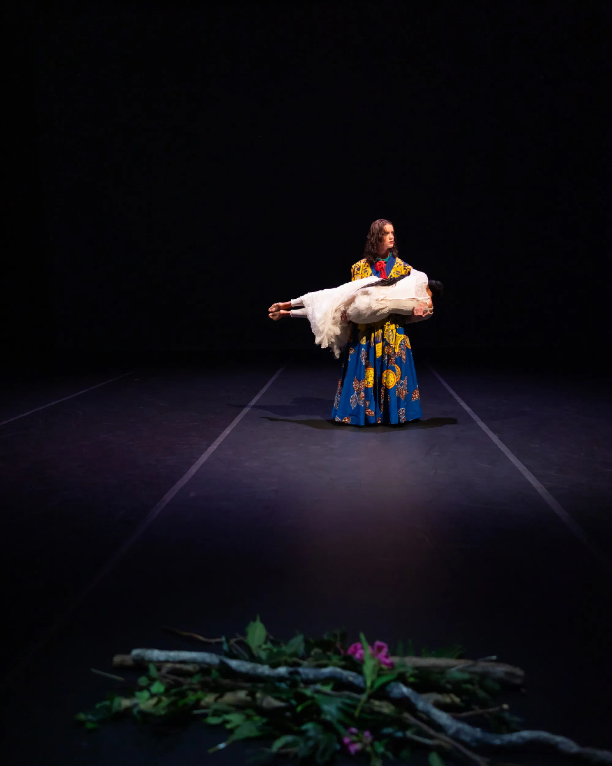A dancer holds a woman wearing a white dress
