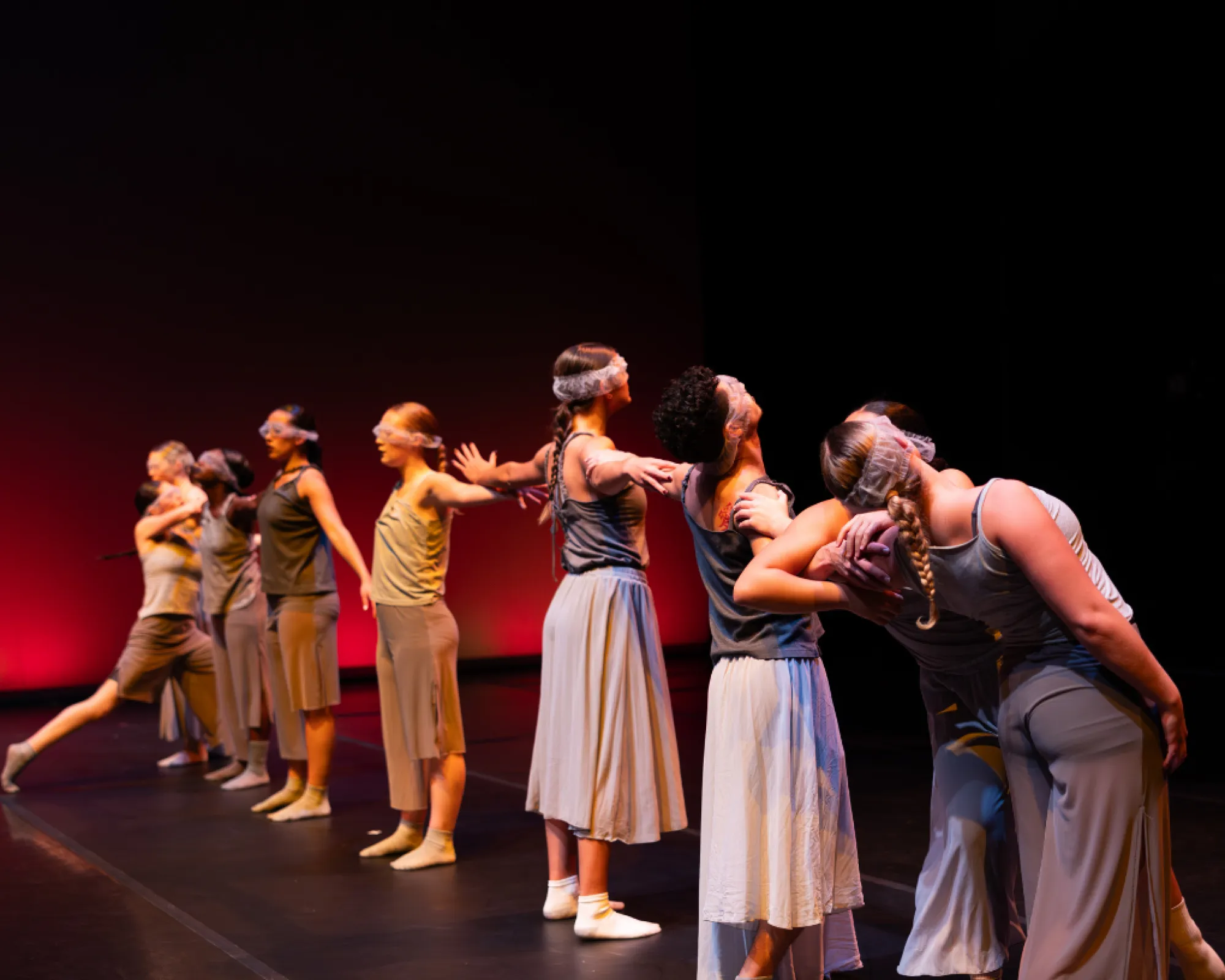 A line of dancers connects arms