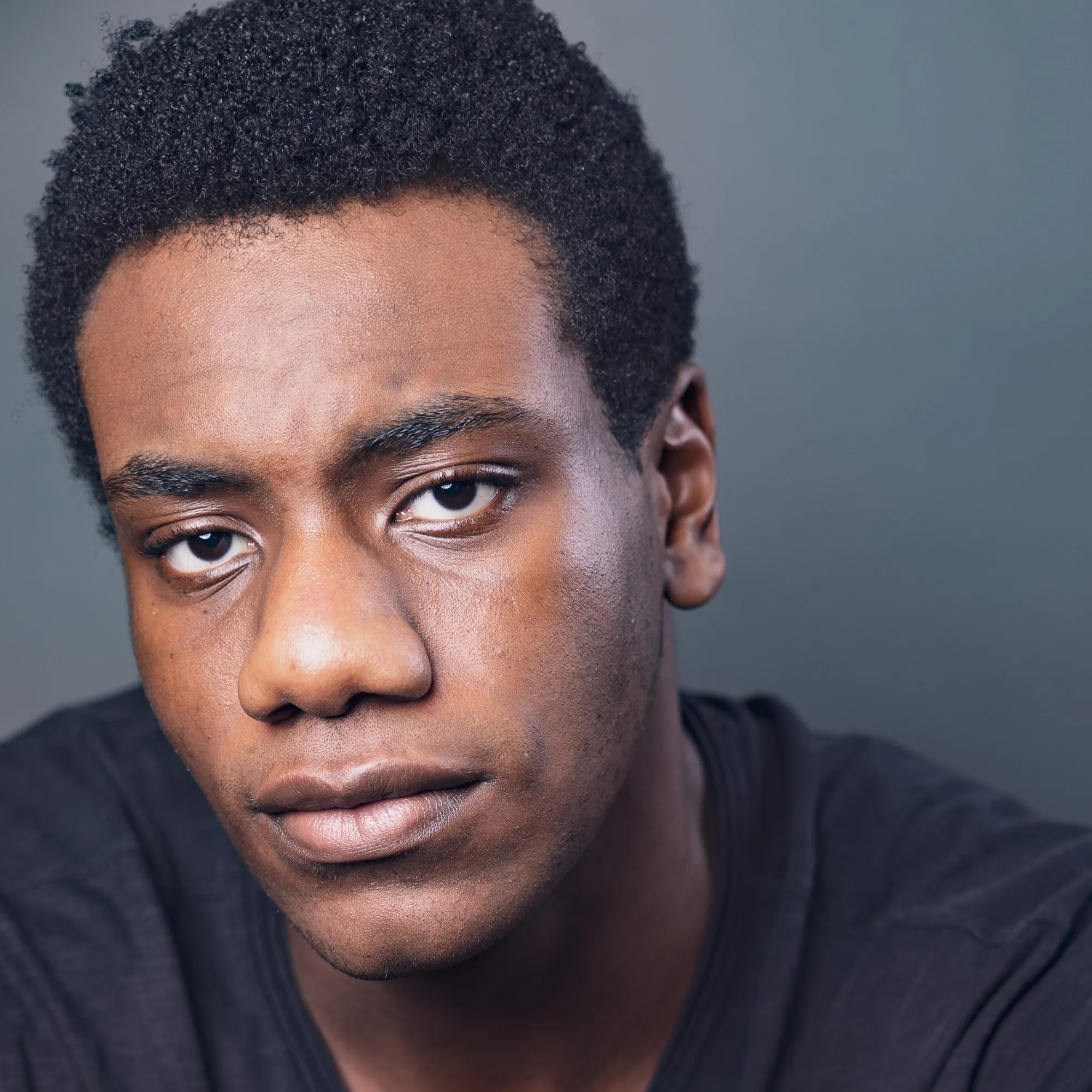 A man with short black hair wearing a black shirt