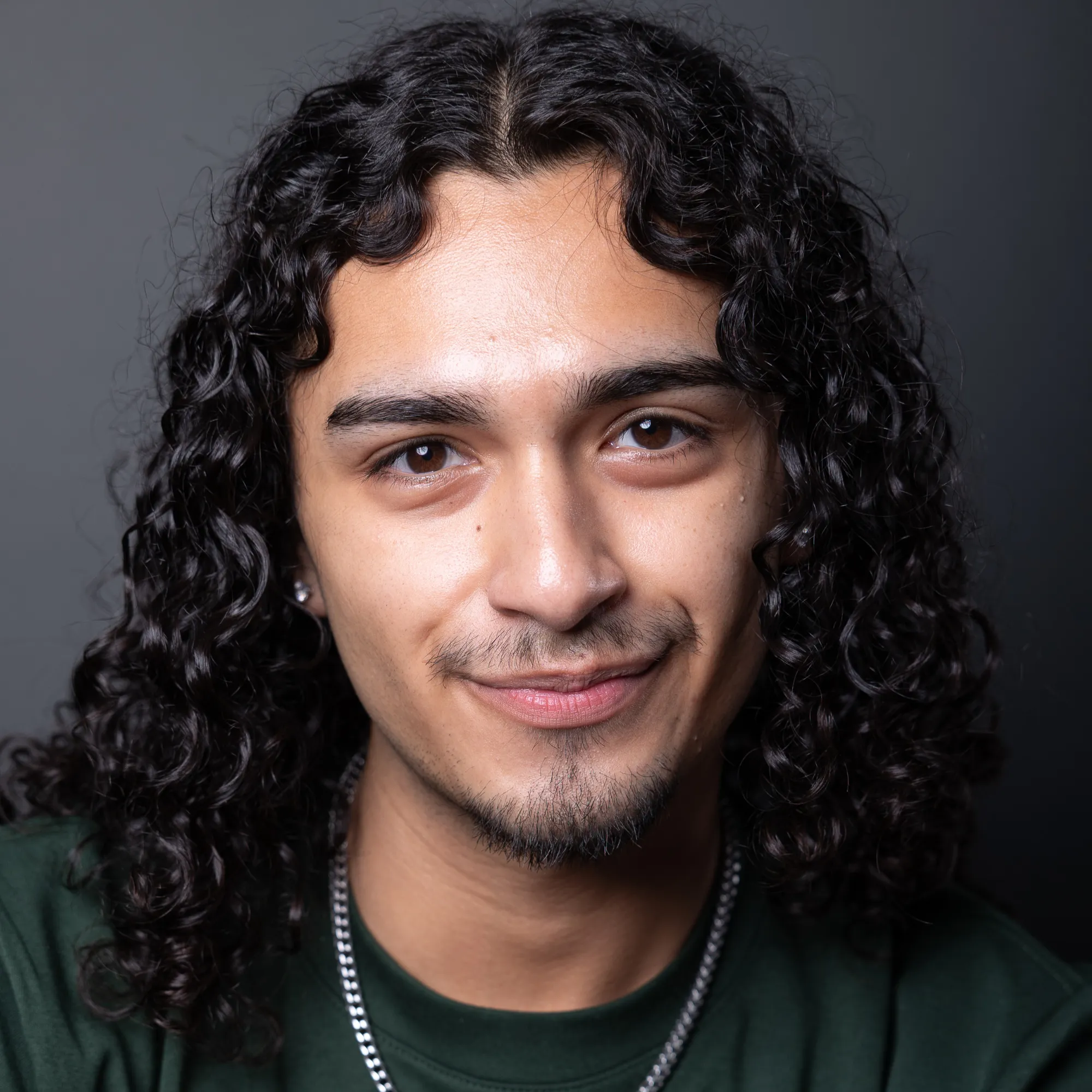 A man with long curly hair smiles
