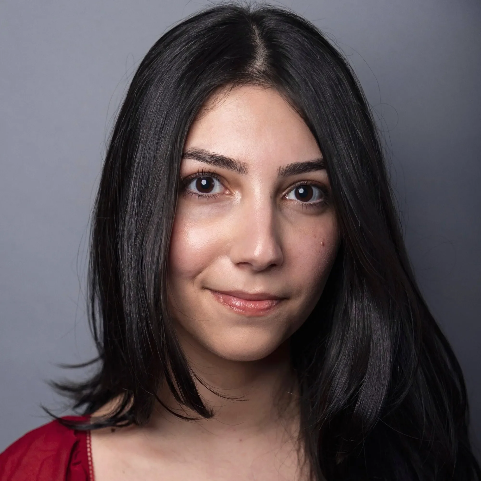 A woman with long black hair wearing a red blouse