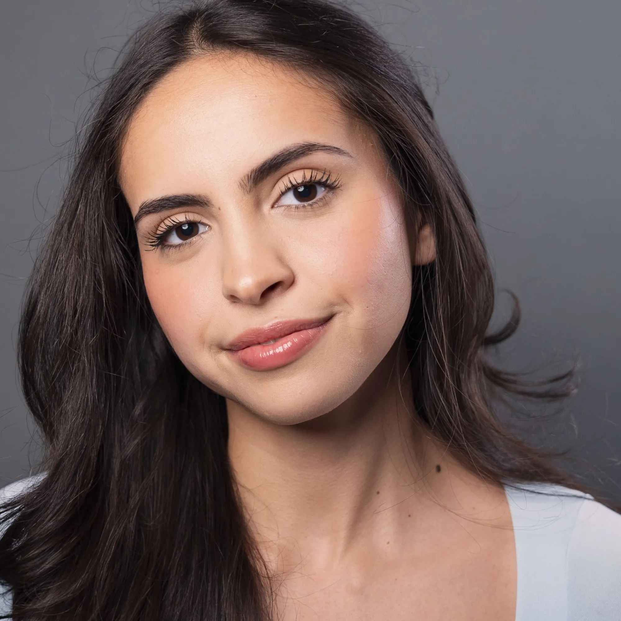 A woman with long brown hair wearing a light blue shirt