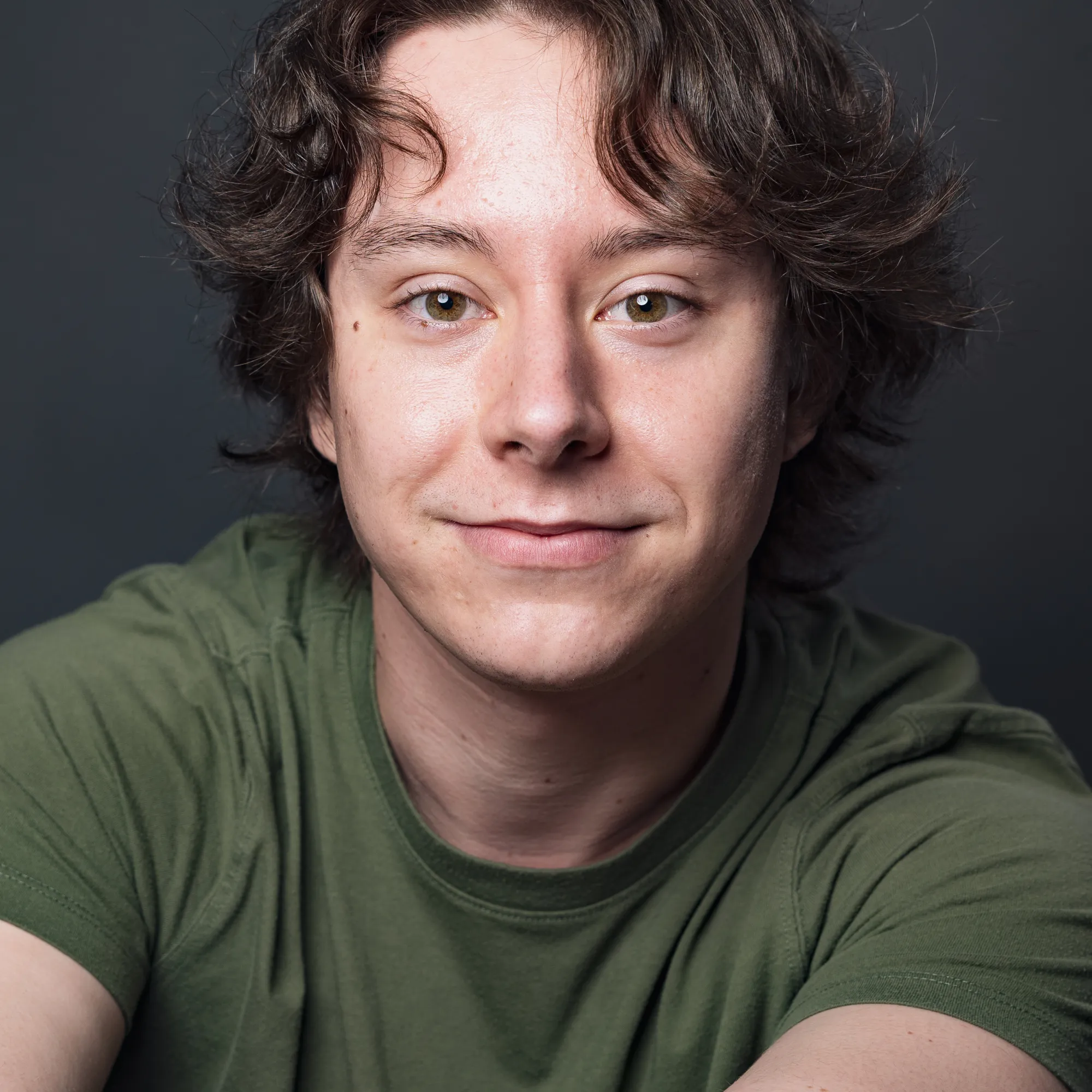 A woman with short brown hair wearing a green shirt
