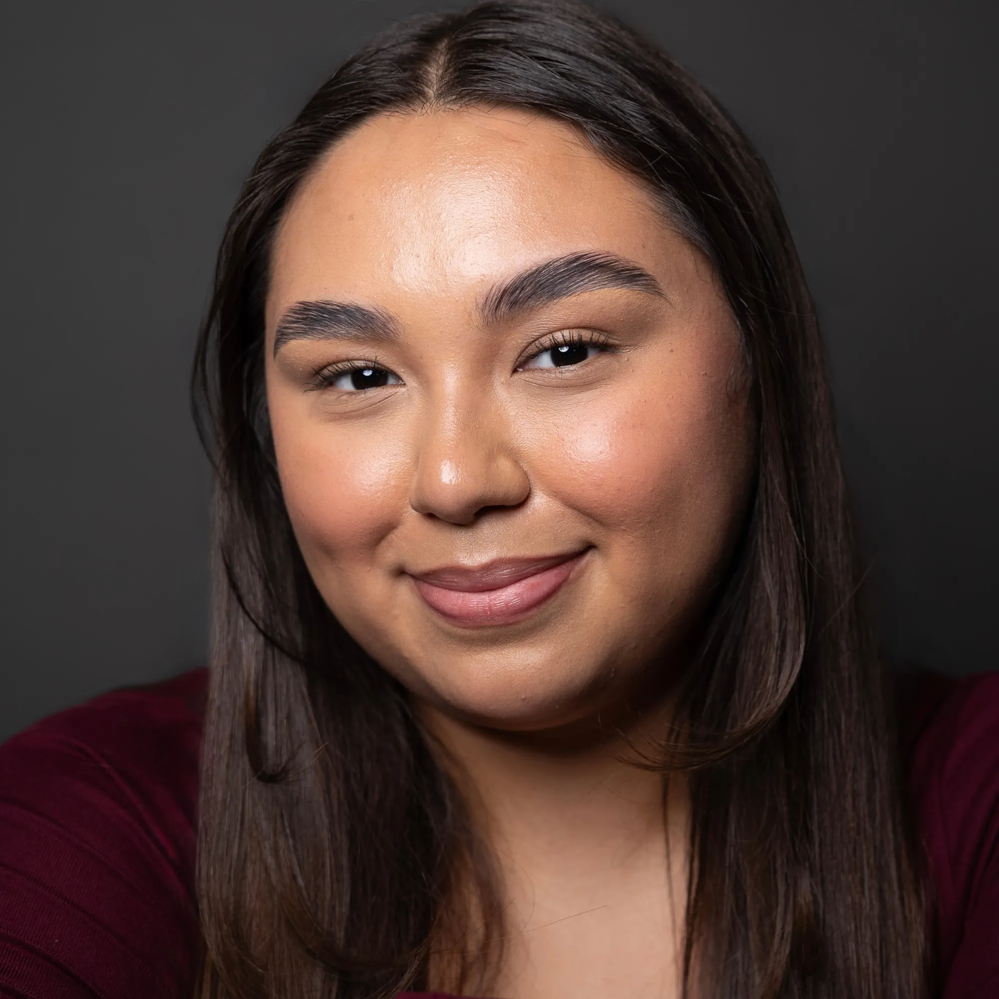 A woman with long brown hair smiles