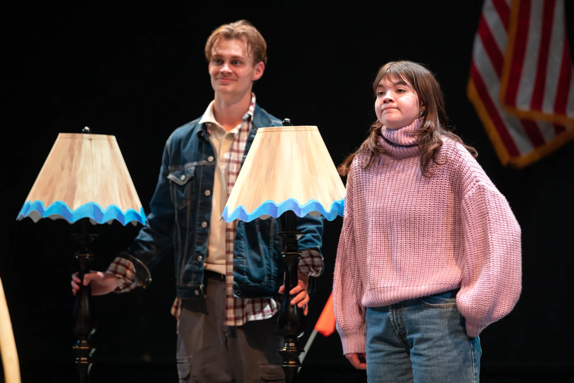 A girl and man stand with two lamps