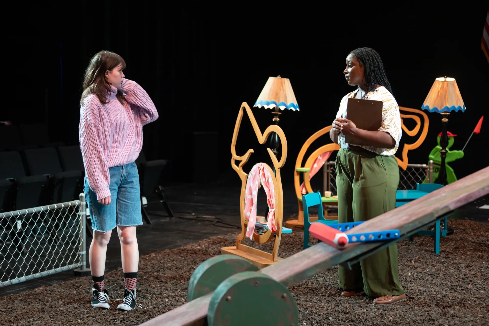 Two women stand on a playground