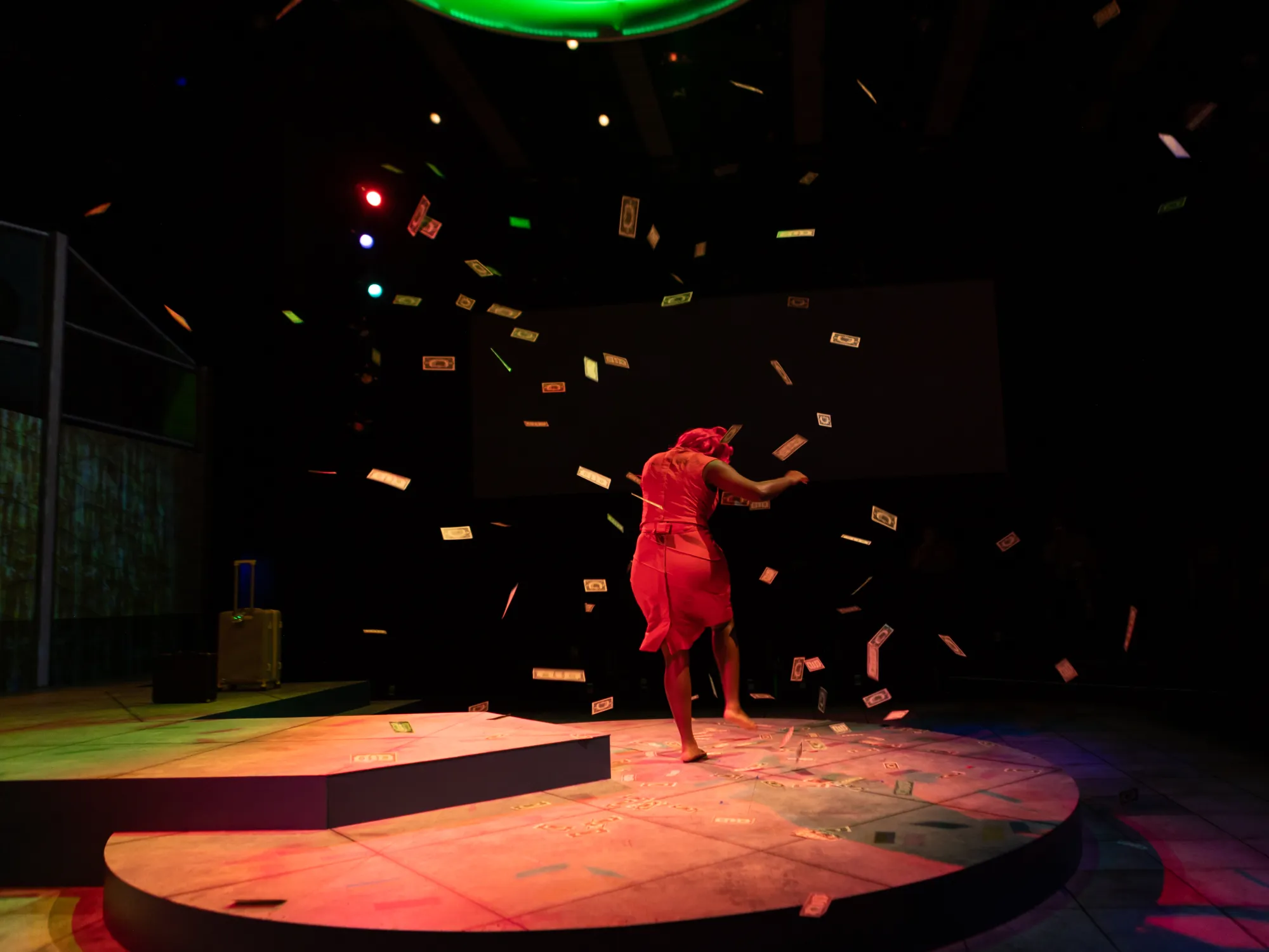 An actor runs in fear while money descends from above