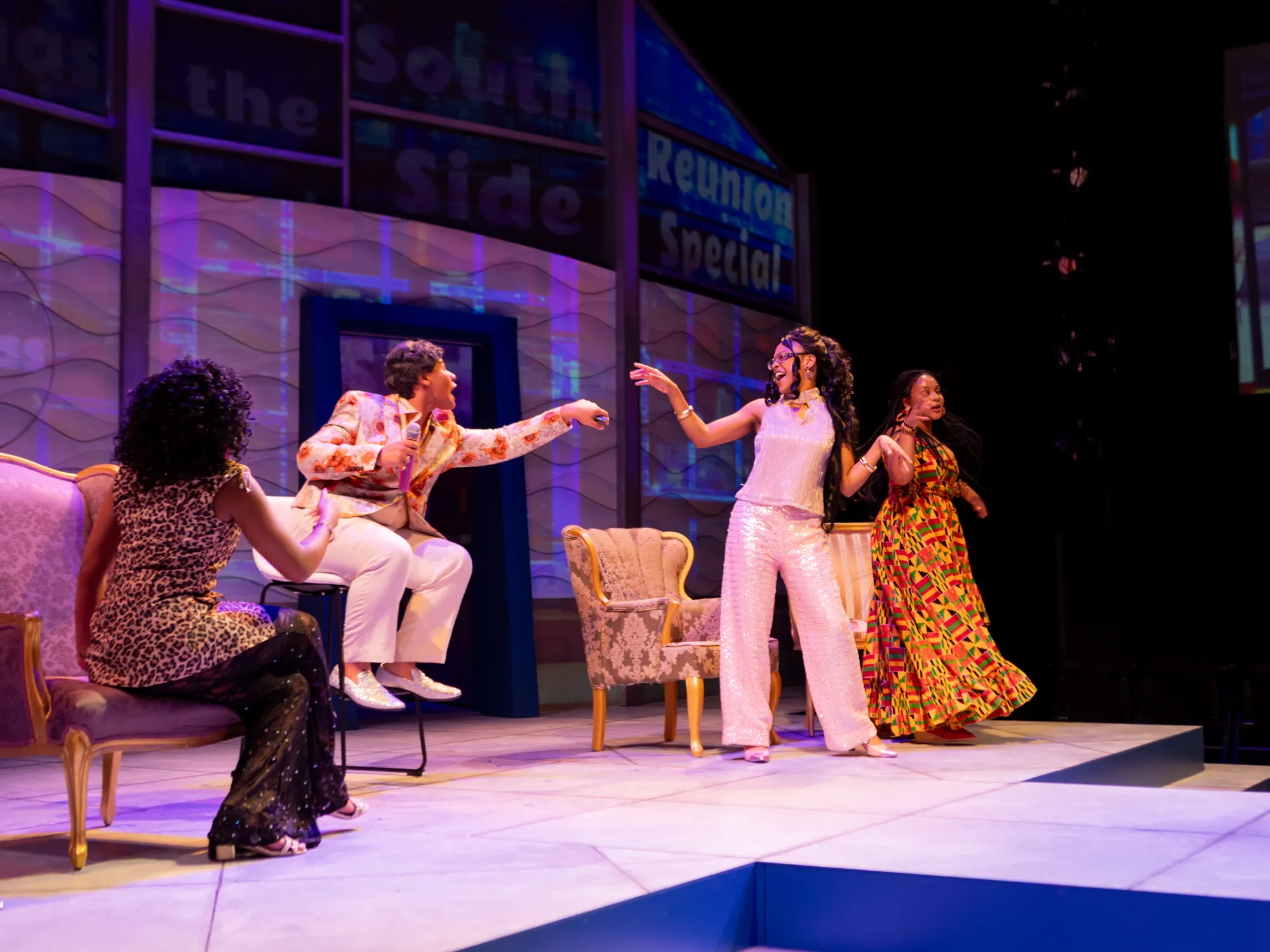 A group of women cheer with a reality television host