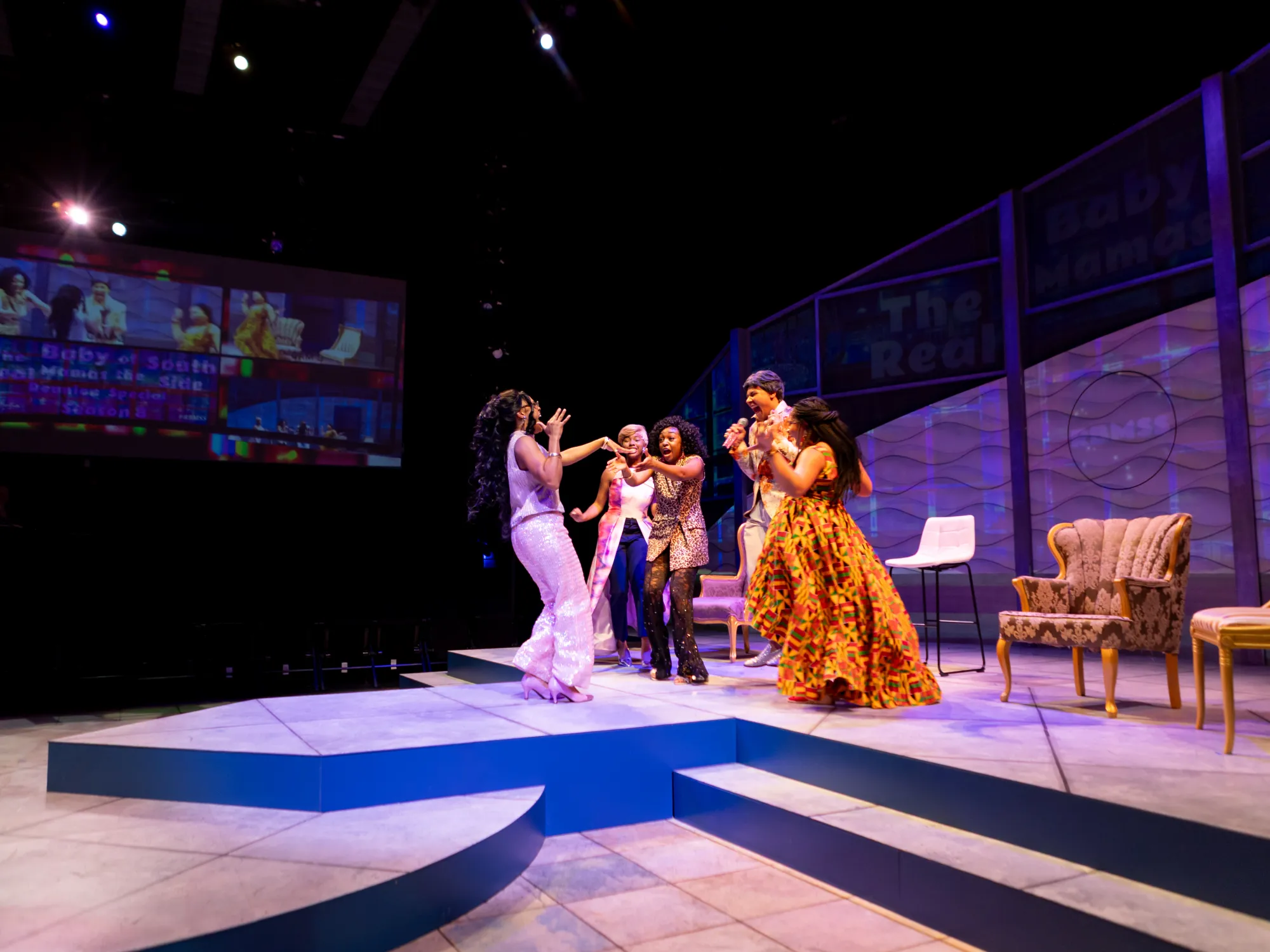 A group of actors stand in a circle and cheer