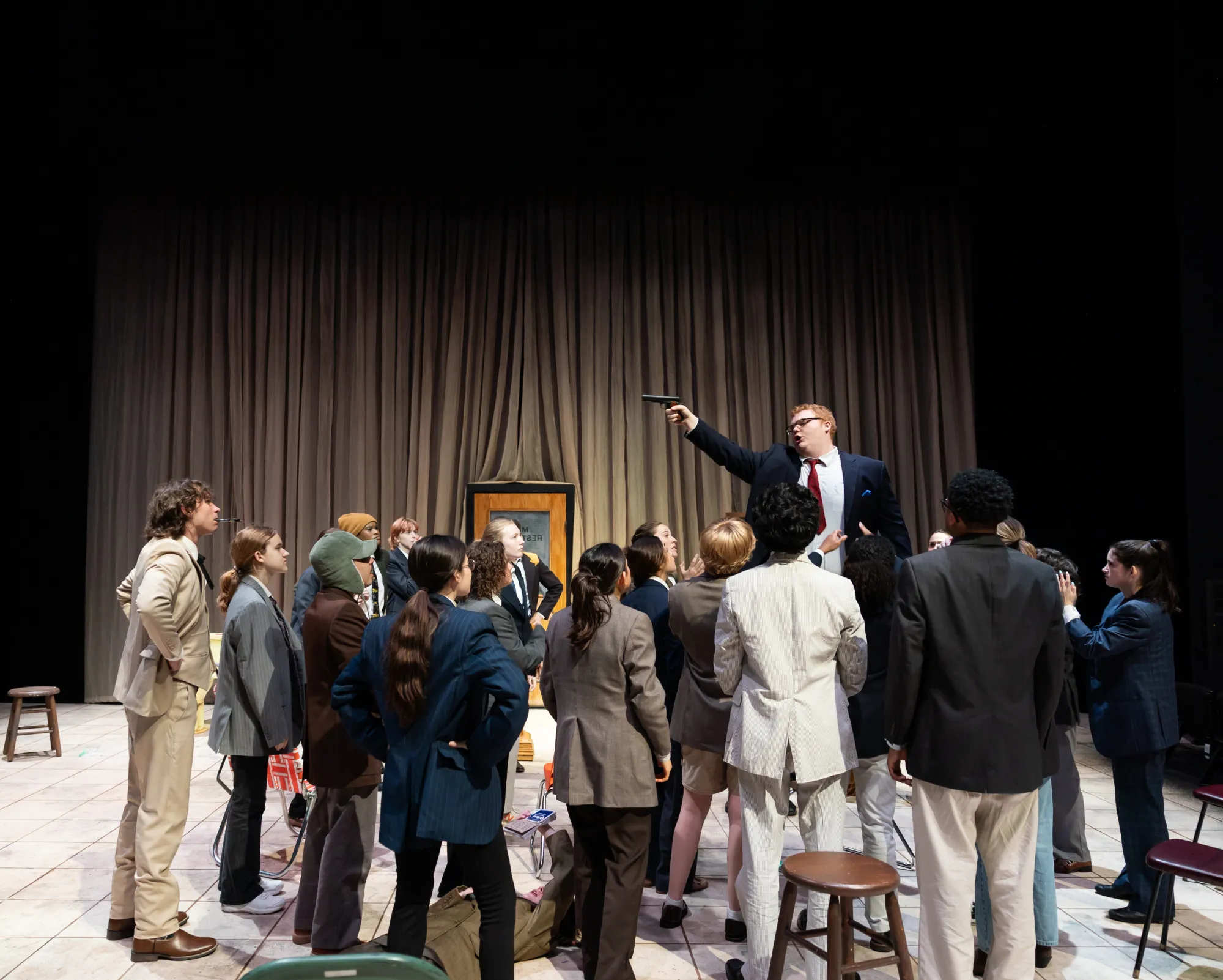 A group of senators stands around one holding a gun