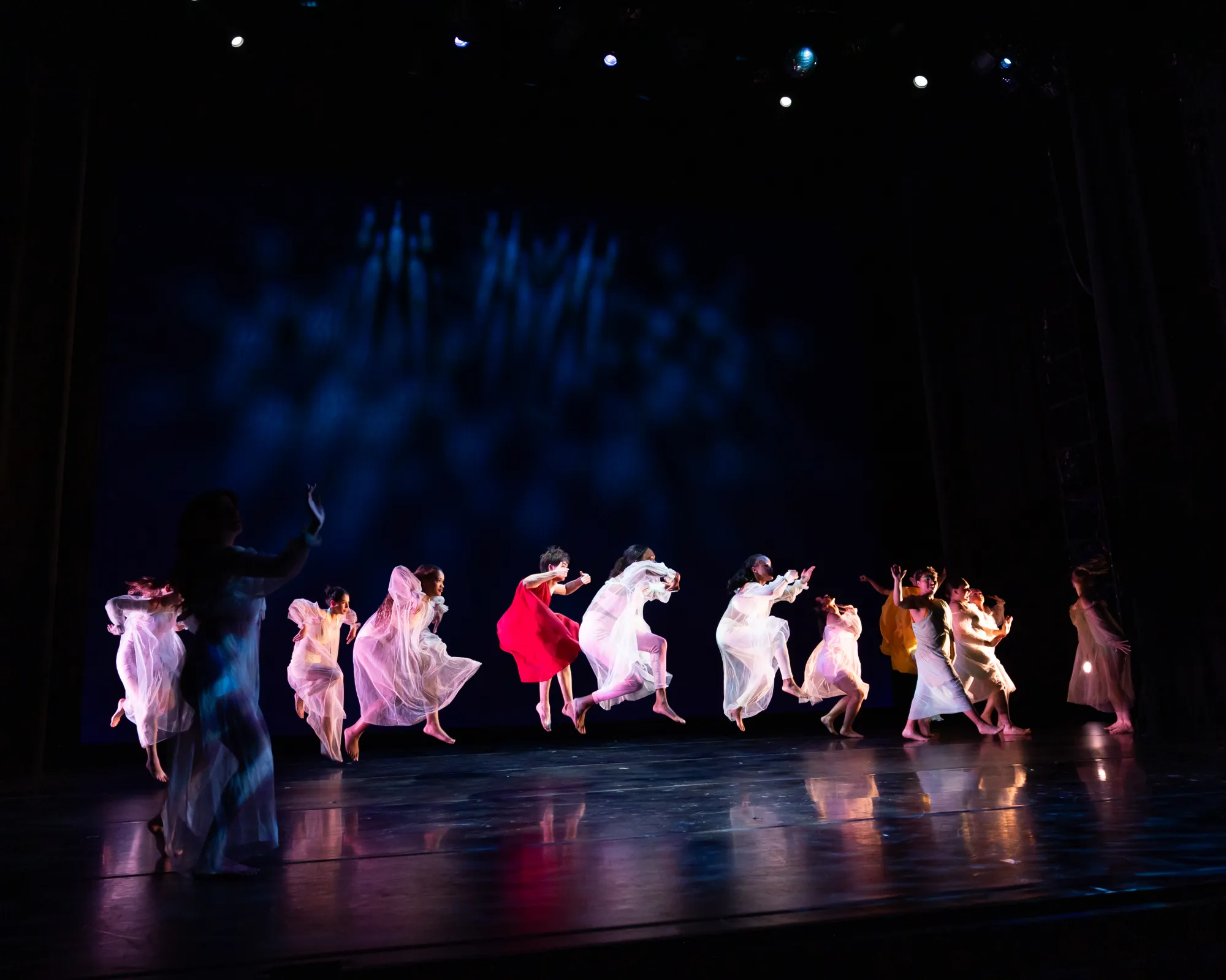 Dancers running in a circle jump together