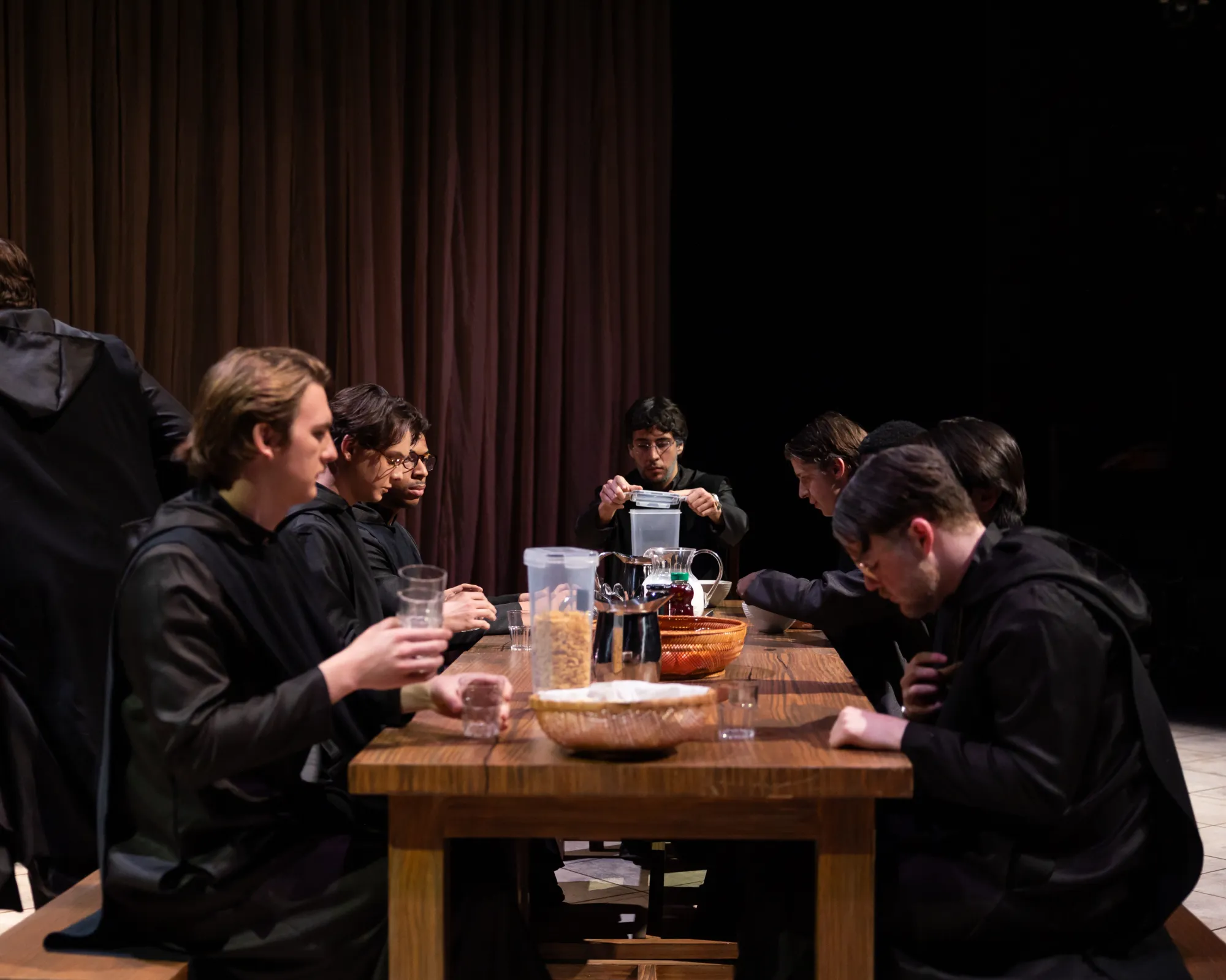 A group of monks sits and eats at a table