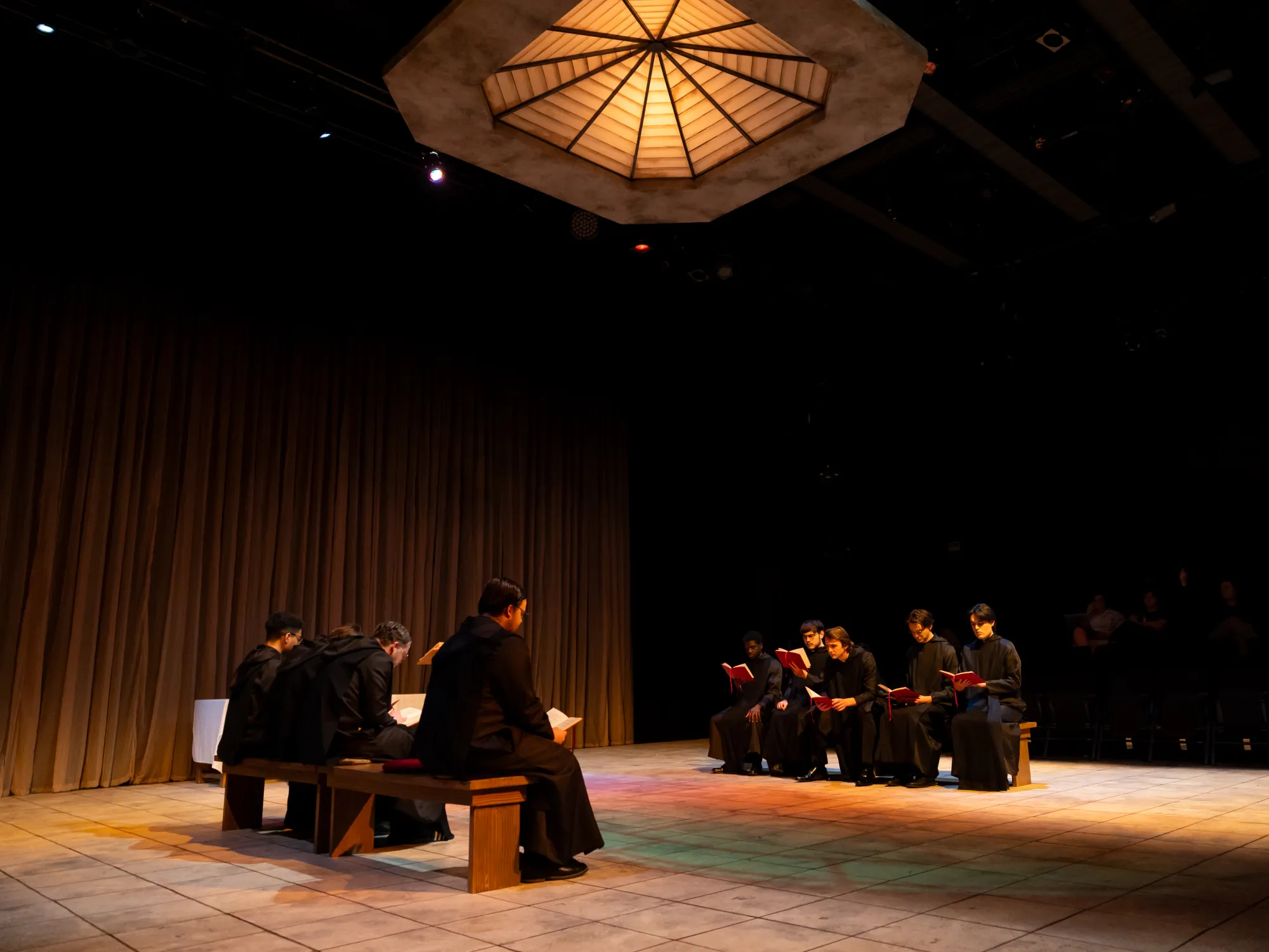 A group of monks sits at mass