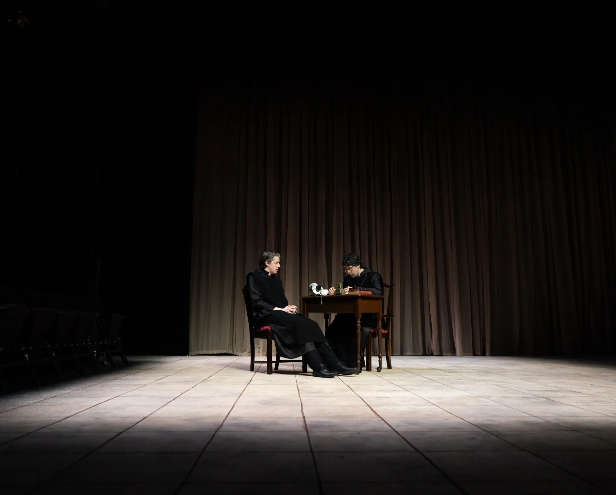 Two monks sit at a desk