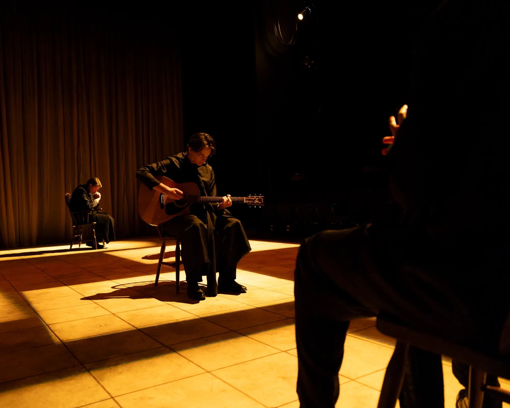 A monk sits and plays the guitar