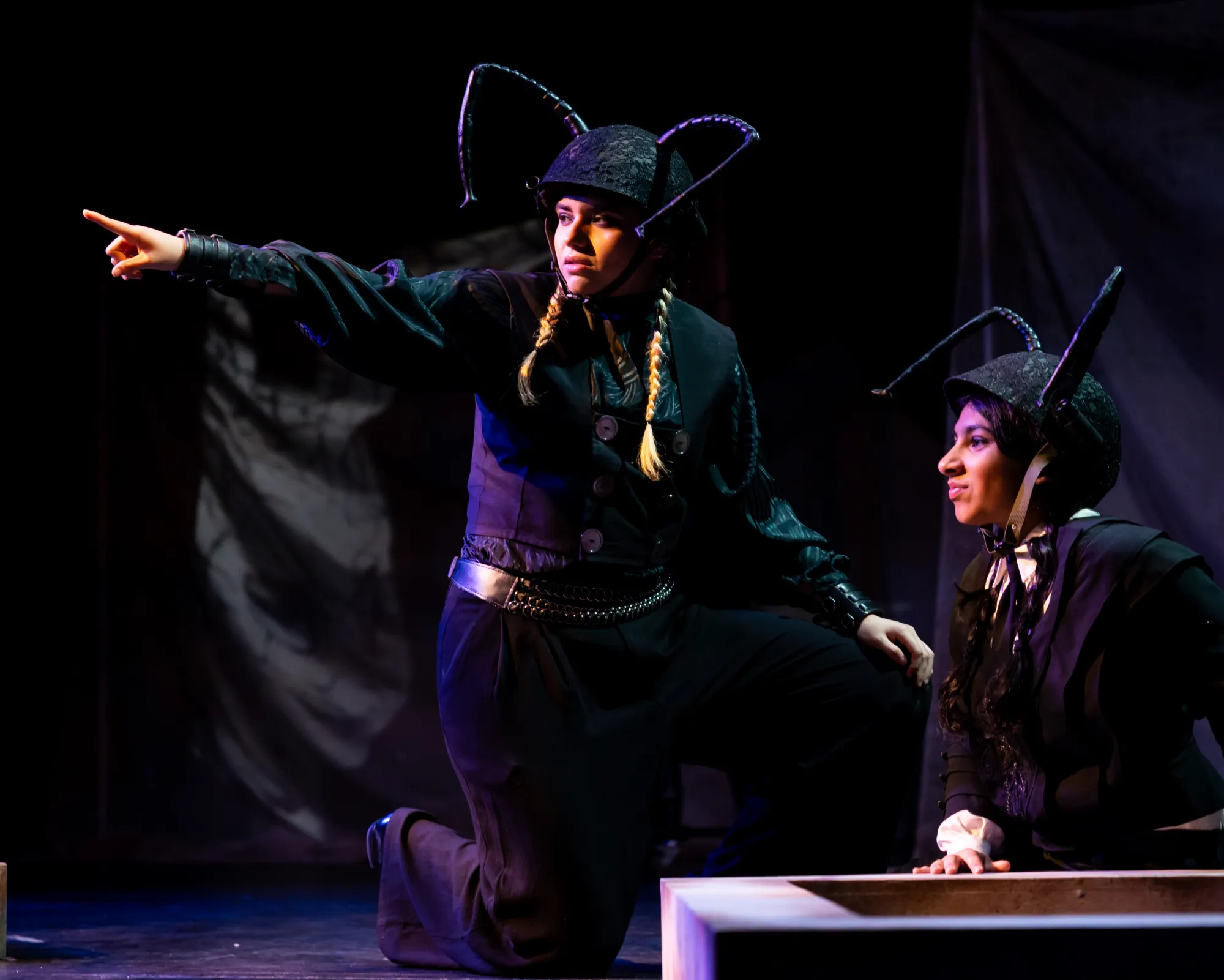 An actor dresses as an ant points