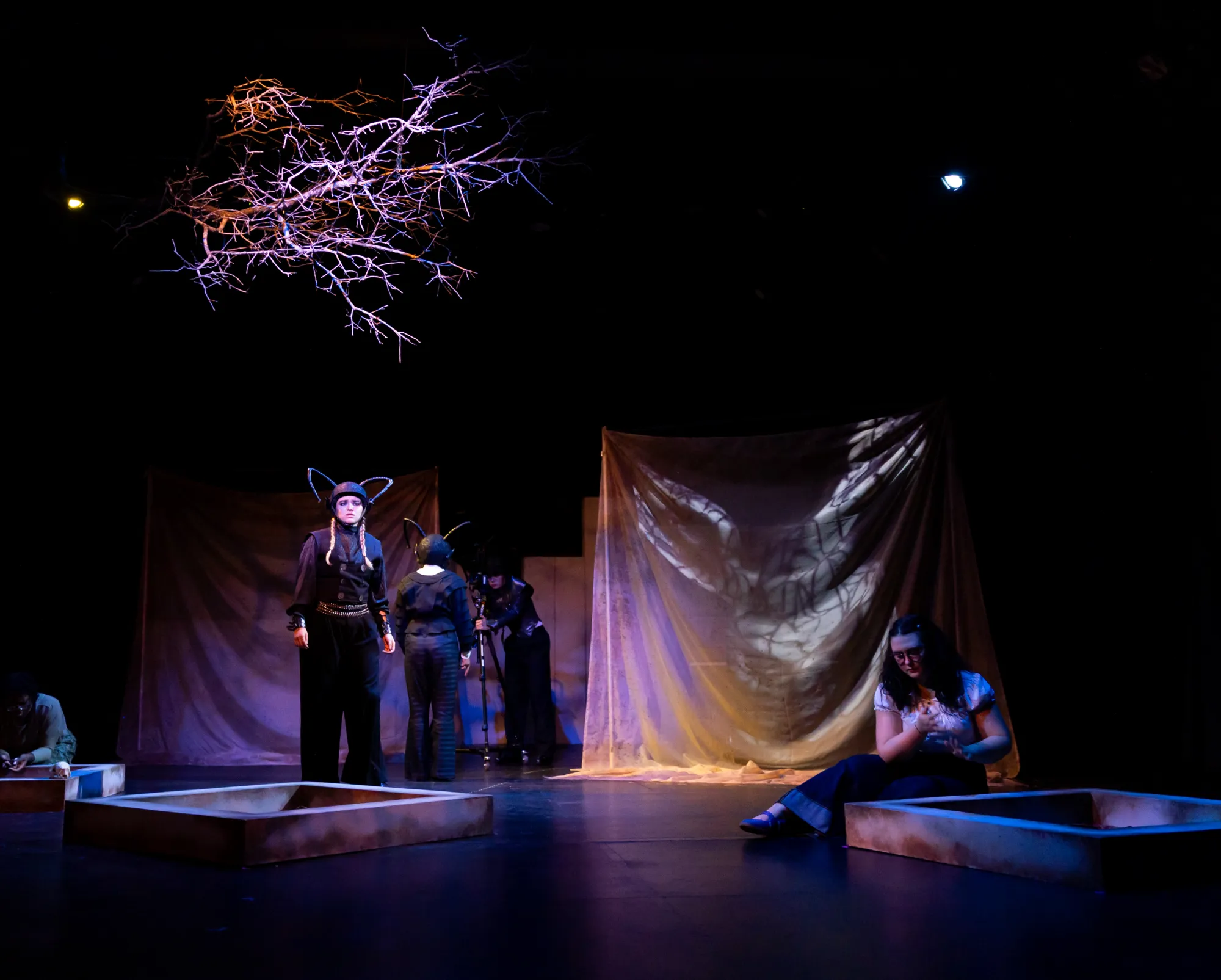 Two actors dressed as ants look outwards