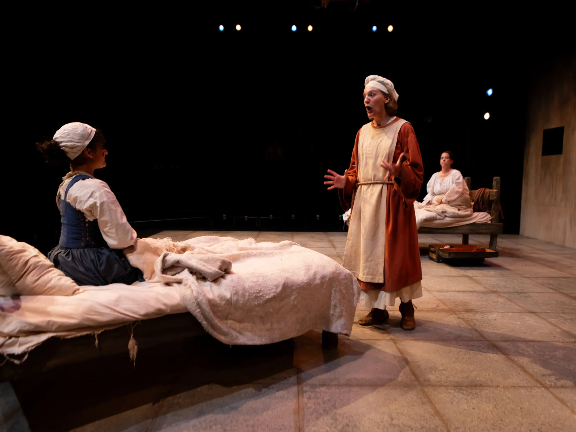 A postulant in a red robe gestures