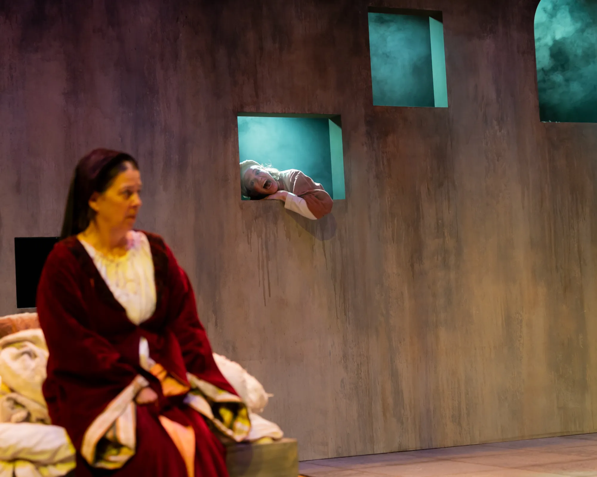 A girl leans through a window with her mouth open