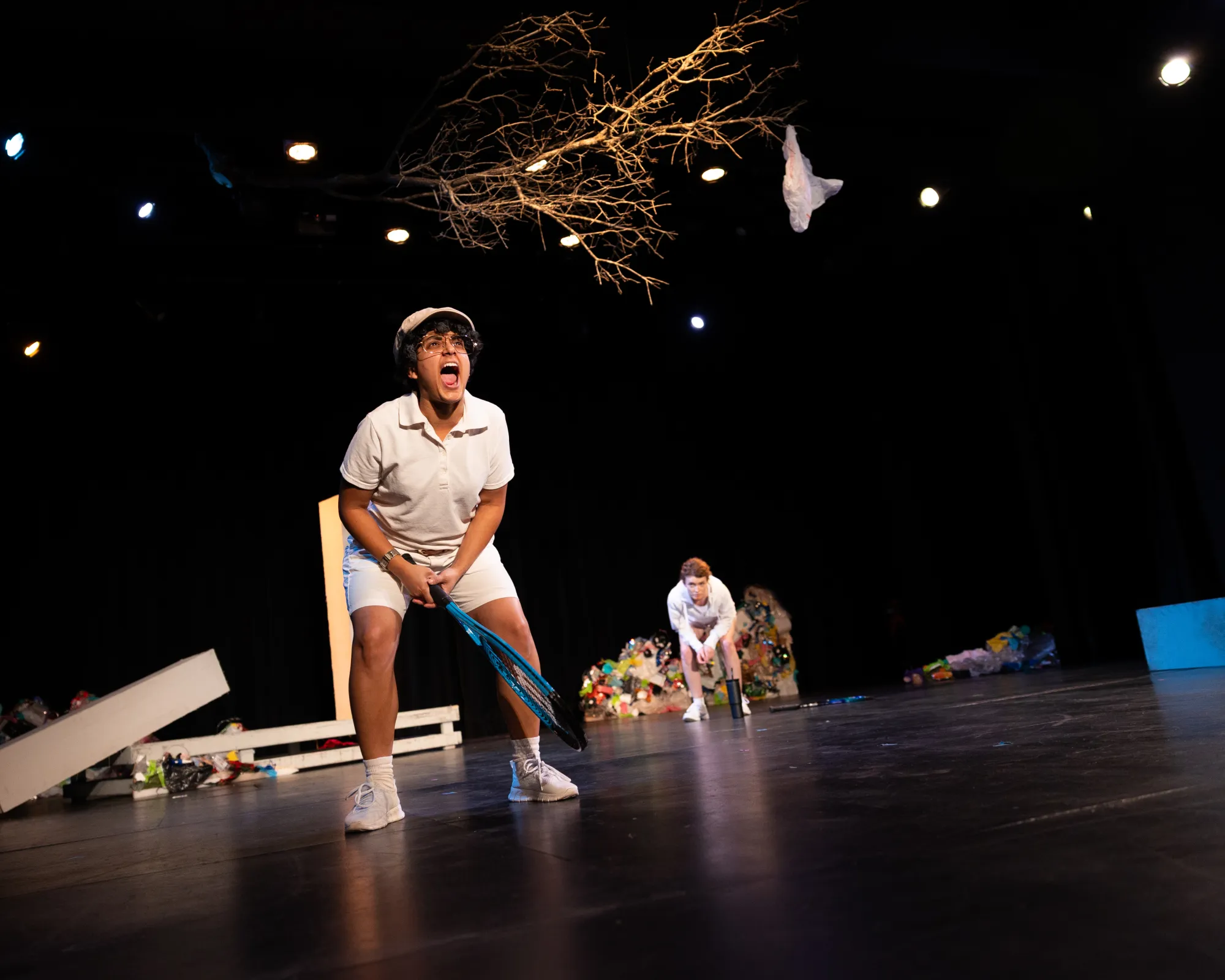 A person in a white tennis outfit yells