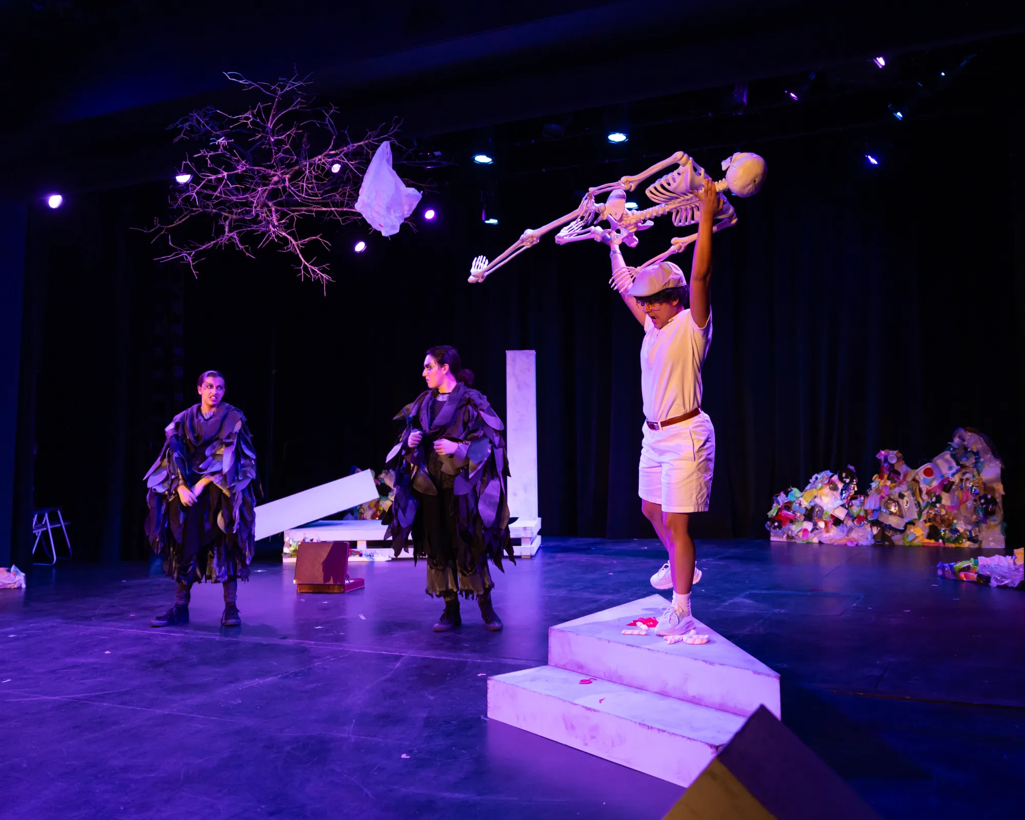 An actor hoists a skeleton into the air