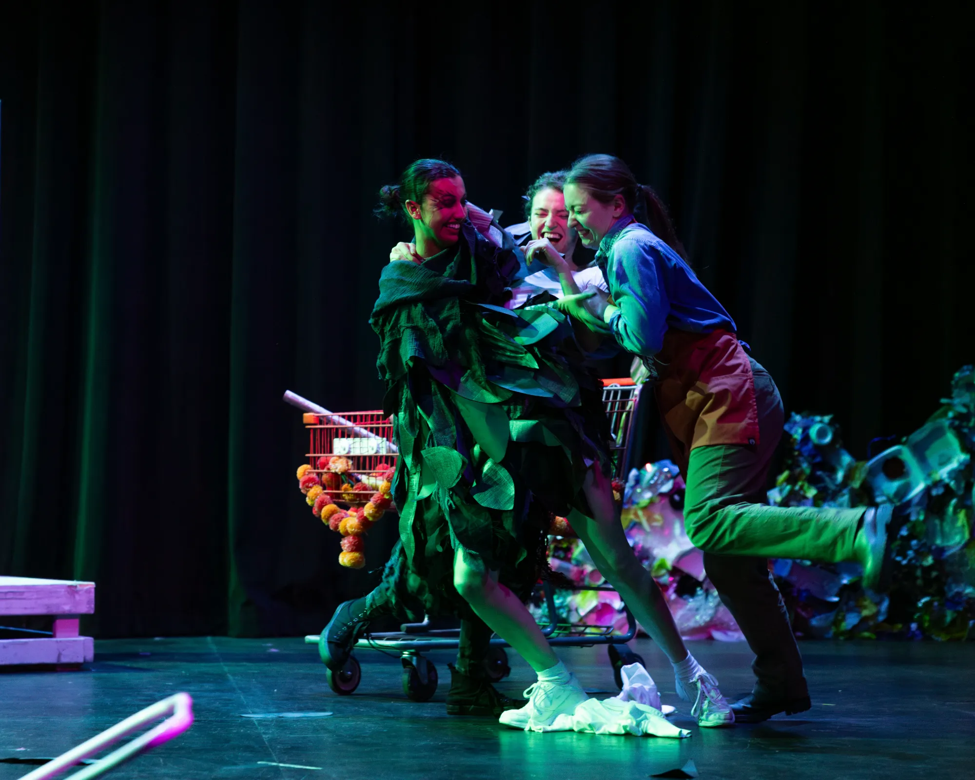 Three actors dance and smile