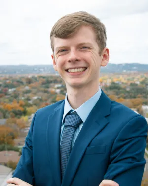 Photo of Ethan Sebree in a dark blue suit 