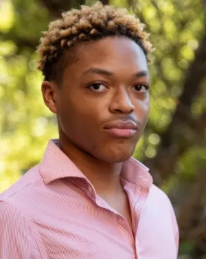 Photo of Isaiah Jones in a peach button down