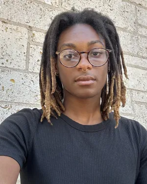 A person with locs and a black shirt