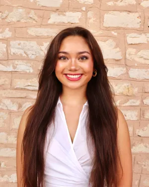 A woman with long brown hair smiles