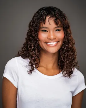A woman with brown curly hair smiles